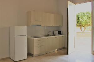a kitchen with white cabinets and a white refrigerator at Zibibbo Beach Apartments - Trapani in Trapani