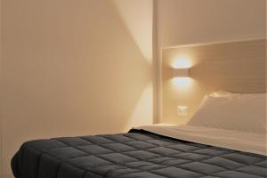 a bedroom with a bed with a headboard at Zibibbo Beach Apartments - Trapani in Trapani