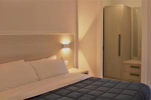 a bedroom with a bed and a cabinet in it at Zibibbo Beach Apartments - Trapani in Trapani