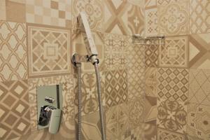 a shower in a bathroom with a tile wall at Zibibbo Beach Apartments - Trapani in Trapani