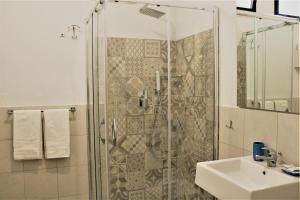 a bathroom with a glass shower and a sink at Zibibbo Beach Apartments - Trapani in Trapani