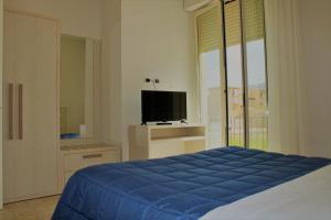 a bedroom with a blue bed and a television at Zibibbo Beach Apartments - Trapani in Trapani