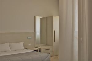 a bedroom with a bed and a dresser with a mirror at Zibibbo Beach Apartments - Trapani in Trapani