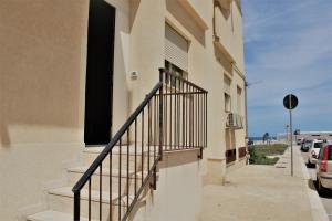 a building with a staircase next to a street at Zibibbo Beach Apartments - Trapani in Trapani