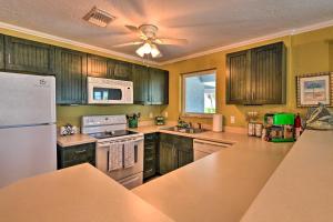 - une cuisine avec des placards en bois et un réfrigérateur blanc dans l'établissement Bright Coastal Condo Walk to Lido Key Beach!, à Sarasota