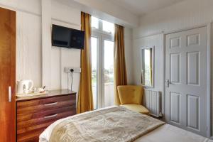 a bedroom with a bed and a chair and a window at Palm Court in Skegness