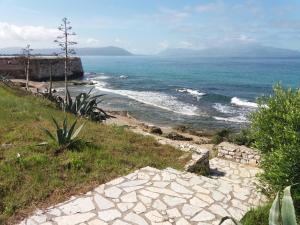 a stone path leading down to a beach with the ocean at Nestor Sea Studio in Preveza