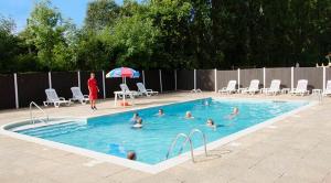 a group of people swimming in a swimming pool at Oakdene -3 Bedroom Caravan in Weeley