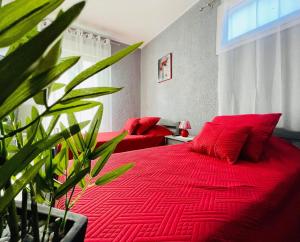 1 dormitorio con cama roja y manta roja en L organdi, en Cornebarrieu