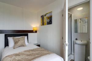 a small bedroom with a bed and a mirror at Palm Court in Skegness