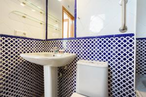 a blue and white bathroom with a sink and a toilet at Apartamentos Pepe Mesa in Nerja +82 photos