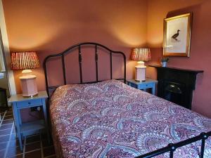 a bedroom with a bed and two tables with lamps at Killee Cottage in Mitchelstown