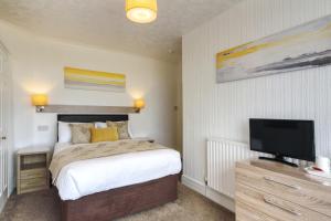 a bedroom with a bed and a flat screen tv at Palm Court in Skegness