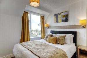 a bedroom with a large bed with a window at Palm Court in Skegness