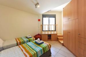 Habitación pequeña con 2 camas y ventana en WONDERFUL ECO FRIENDLY VILLA AUGUSTINE, en Ambelón