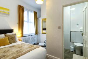 a hotel room with a bed and a toilet at Palm Court in Skegness