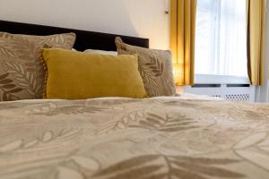 a bed with two pillows and a bed with a window at Palm Court in Skegness