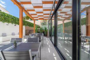 an outdoor patio with tables and chairs and windows at Roots Hotel in Faro