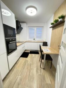 a small kitchen with a table and a dining room at Apartament confortabil Alba Iulia in Alba Iulia