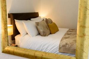 a mirror reflection of a bed with pillows at Palm Court in Skegness