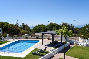 uma piscina com uma mesa e um guarda-sol em VillaCasa Marbella em Marbella