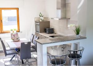 eine Küche mit einer Theke, einem Tisch und Stühlen in der Unterkunft Ferienwohnung-Bine am Nürburgring in der Eifel in Quiddelbach