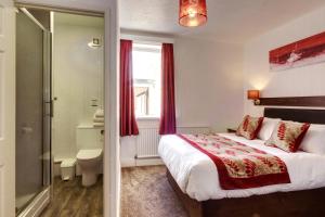 a hotel room with a bed and a bathroom at Palm Court in Skegness