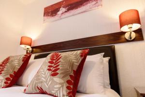 a hotel room with a bed with red and white pillows at Palm Court in Skegness