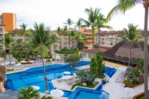an aerial view of a resort pool with palm trees at Canto del Sol Puerto Vallarta All Inclusive in Puerto Vallarta