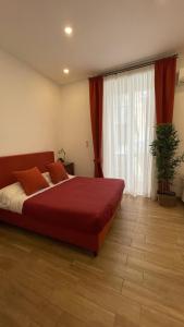 una camera da letto con un grande letto rosso e una finestra di studionapoli112 a Napoli