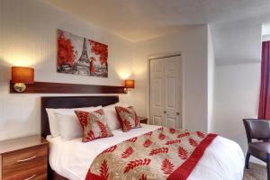 a bedroom with a bed with a red and white blanket at Palm Court in Skegness