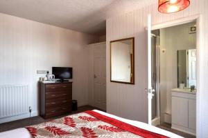 a bedroom with a bed and a dresser and a mirror at Palm Court in Skegness
