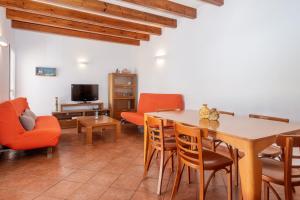 Una sala de estar con una mesa y sillas y un televisor. en Villa Payu, en Ciutadella