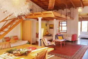 een woonkamer met een loft met een tafel en stoelen bij Alegría Aire - Eco Retreat Finca Artis Tirma in Tarajalejo