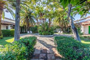 a garden with palm trees and a walkway at Hotel-Apart CORTIJO LAS PIÑAS in Tarifa
