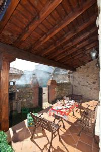 a patio with a table and chairs and a grill at Las Cabañas de Pimiango in Colombres