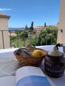 una cesta de pan y un libro sobre una mesa en Appartamenti Supramonte, en Santa Maria Navarrese