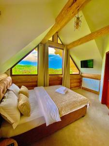 Casa Crăciun في Valea Nandrului: غرفة نوم بسرير مع نافذة كبيرة