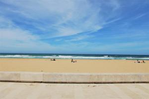 a beach with people on the sand and the ocean at Zibibbo Beach Apartments - Trapani in Trapani