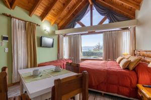 a bedroom with a bed and a table and a window at Lagos del Sur in San Carlos de Bariloche