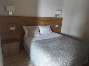 a bedroom with a bed with a wooden headboard at Casa Rústica O Facho in Hio