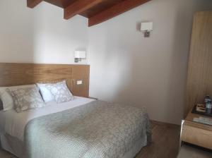 ein Schlafzimmer mit einem großen Bett und einem Kopfteil aus Holz in der Unterkunft Casa Rústica O Facho in Hio