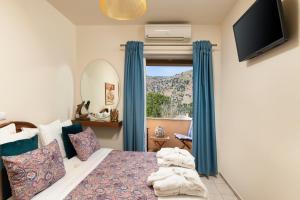 um quarto com uma cama com cortinas azuis e uma janela em Villa Cressida em Kávallos
