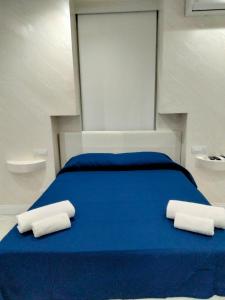 a blue bed with two white towels on it at DuoArianna in Naples