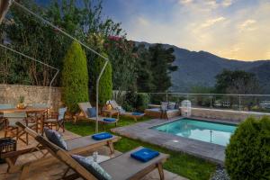 um quintal com uma piscina, uma mesa e cadeiras em Villa Cressida em Kávallos