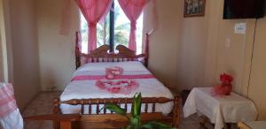 1 dormitorio con cama con sábanas rosas y ventana en Pal's on the beach - Dangriga, Belize, en Dangriga 82 fotos más