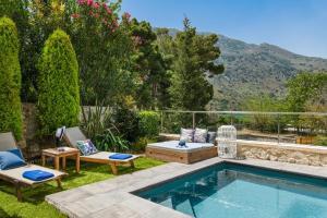 a swimming pool in a yard with two lounge chairs at Villa Cressida in Kávallos