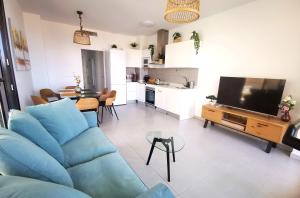 a living room with a blue couch and a television at Superior Calpe Pearl Beach in Calpe