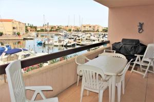 a balcony with a table and chairs and a marina at Amirauté I 21 2pieces 4 personnes in Saint-Cyprien