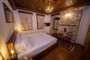 培拉特Berati Castle Hotel的一间卧室配有一张床和一个石头壁炉